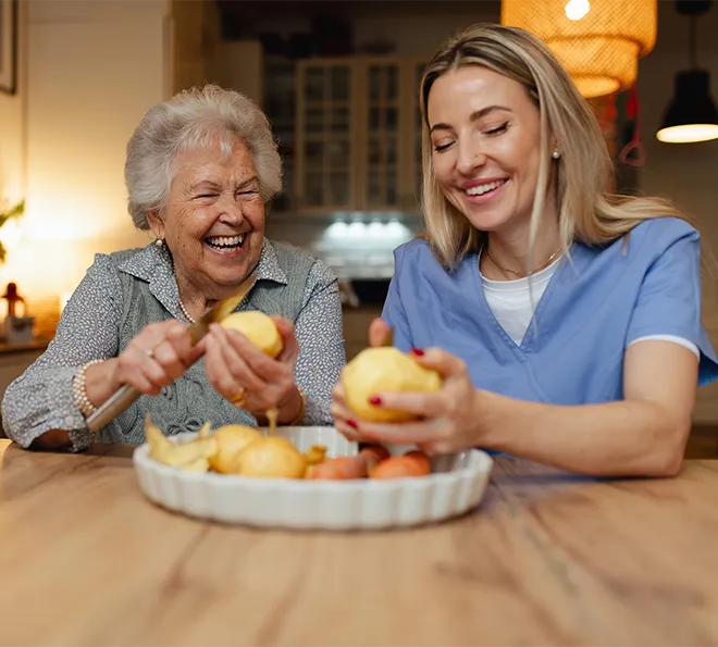 A live-in home health aide peels vegetables with her patient in Potomac, MD